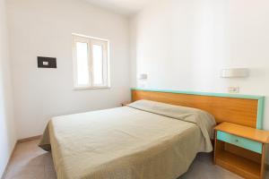 a small bedroom with a bed and a table at Villaggio Club In in Vieste