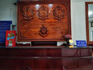un mur en bois avec une plaque au-dessus d'un bureau dans l'établissement Truong An Hotel, à Vung Tau