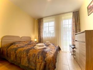 a bedroom with a bed with two towels on it at Karkle Seaside Apartments in Karklė
