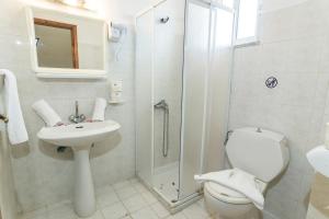 a bathroom with a shower and a toilet and a sink at Tivoli Hotel in Faliraki