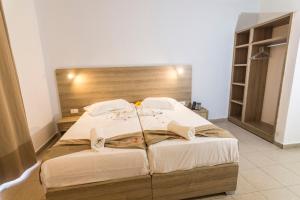 a bedroom with a large bed with a wooden headboard at Tivoli Hotel in Faliraki