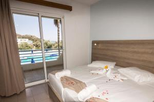 a bedroom with a bed with a large window at Tivoli Hotel in Faliraki +114 photos
