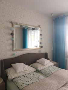 a bedroom with a bed with a mirror on the wall at Apartament FALA-Miodowy Dom in Kołobrzeg