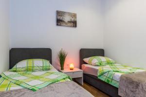 una habitación con dos camas y una mesa con lámpara en Rooms and Apartments Budiša, en Vrlika