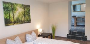 ロイテにあるApartements Breitenwangのベッドルーム1室(ベッド1台付)が備わります。壁には絵画が飾られています。