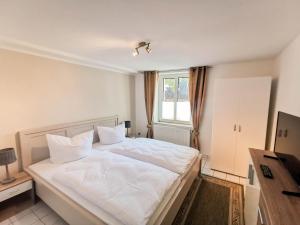 una camera da letto con un letto con lenzuola bianche e una finestra di Ferienhaus Garz a Garz