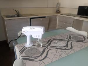 Le Vele Residence في بيترا ليغوري: وجود آلة خياطة جالسة على طاولة زجاجية في مطبخ