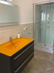 y baño con lavabo amarillo y ducha. en Golden House, en Palmi