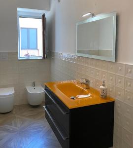 bagno con lavandino, servizi igienici e specchio di Golden House a Palmi