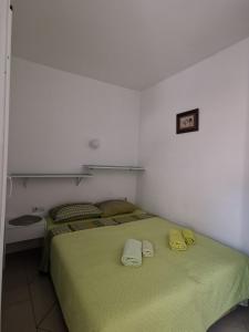 una camera con 2 letti con lenzuola verdi e cuscini gialli di Apartments Coso Zlatne njive bb a Kotor (Cattaro)