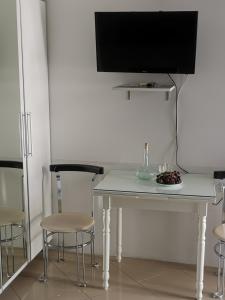 un tavolo con sedie e una televisione sopra di esso di Apartments Coso Zlatne njive bb a Kotor (Cattaro)