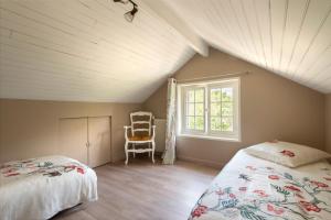 Cette chambre mansardée comprend 2 lits et une fenêtre. dans l'établissement La Petite Affolante, à Samois-sur-Seine