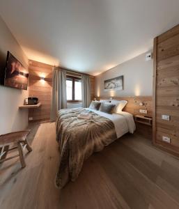a bedroom with a bed and a dresser at Hotel Les Flocons in Les Deux Alpes