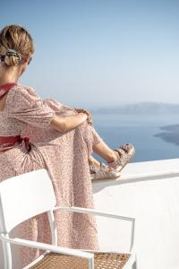 a woman sitting on a bench looking out at the ocean at Veranda View in Imerovigli