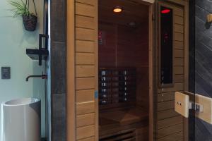 a wooden door leading to a shower in a bathroom at Bed & Breakfast Nummer5 in Heusden - Zolder