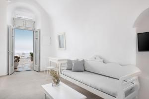 a white living room with a white couch and a table at Veranda View in Imerovigli