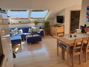 een woonkamer met een blauwe bank en een tafel bij viaDolceVita - Blaue Gästewohnung in Lana