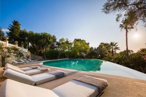 una piscina con tumbonas junto a una piscina en Ionian Garden Villas - Villa Olea en Benitses