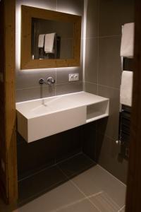 a bathroom with a white sink and a mirror at Hotel Les Flocons in Les Deux Alpes