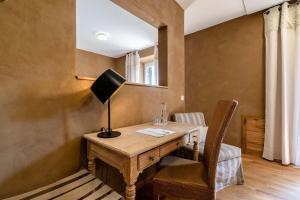 a desk with a lamp and a chair in a room at SEINZ Wisdom Resort - Bio-Hotel vegan-vegetarisch in Bad Kohlgrub