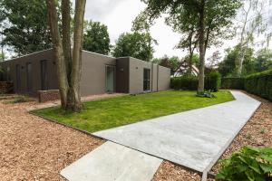 een huis met een betonnen loopbrug in een tuin bij Bed & Breakfast Nummer5 in Heusden - Zolder