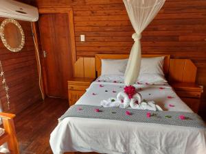 Una cama con flores y animales de peluche. en East Africa Safaris en Chizavane