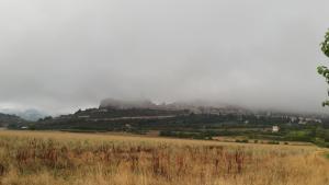 una collina nebbiosa con una città in cima di Sulla Strada di San Francesco ad Assisi