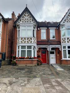 ein rotes Backsteinhaus mit einer roten Tür in der Unterkunft 38 Whitehall Road in Harrow on the Hill