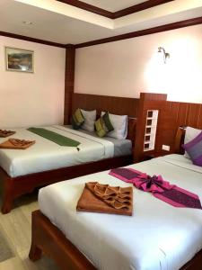 a bedroom with two beds with towels on them at Grand Beach Resort in Ko Tao