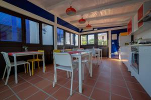 a kitchen with tables and chairs and windows at B&B Le Saline in Syracuse