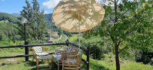 a couple of chairs and an umbrella on a balcony at Ca' du Tu in Masone