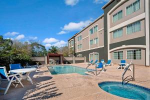 ein Hotel mit einem Pool und Stühlen sowie einem Gebäude in der Unterkunft La Quinta by Wyndham Brownsville North in Brownsville