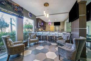 a lobby with a bar with chairs and a counter at La Quinta Inn & Suite Kingwood Houston IAH Airport 53200 in Kingwood