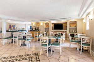 a restaurant with tables and chairs and a tv at La Quinta Inn by Wyndham El Paso West in El Paso