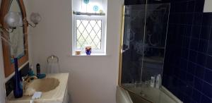 a bathroom with a shower and a sink and a window at Wychwood House in Tenby +51 photos