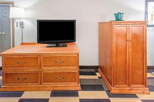 a tv on a wooden dresser next to a wooden cabinet at La Quinta by Wyndham Oklahoma City - Moore in Moore