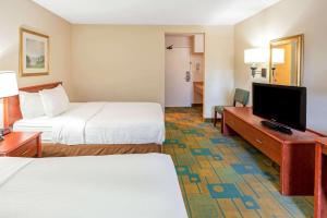 a hotel room with two beds and a flat screen tv at La Quinta Inn by Wyndham Milwaukee Airport / Oak Creek in Oak Creek