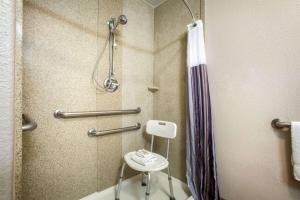 a shower in a hotel bathroom with a stool at La Quinta by Wyndham Kyle - Austin South in Kyle