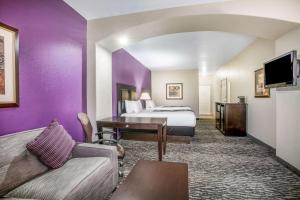 Habitación de hotel con cama extragrande y paredes moradas en La Quinta by Wyndham Kyle - Austin South, en Kyle