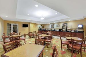 a restaurant with tables and chairs and a bar at La Quinta by Wyndham Stillwater -University Area in Stillwater