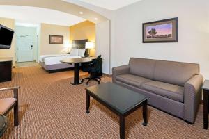 a hotel room with a couch and a bed at La Quinta by Wyndham Stillwater -University Area in Stillwater