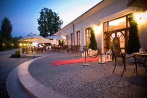 a building with tables and umbrellas on a brick road at Willa Zagórze in Okuniew