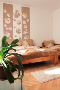 - une chambre avec un lit et une plante en pot dans l'établissement Pogácsás Apartman, à Tokaj