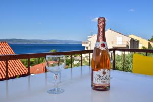 a bottle of wine and a glass on a table at Apartments Mare in Brela