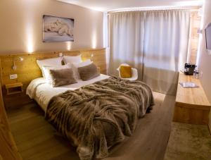 een slaapkamer met een groot bed en een deken bij Hotel Les Flocons in Les Deux Alpes