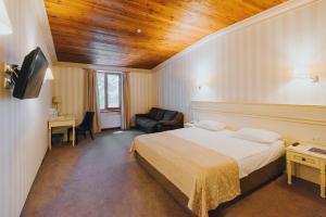 a bedroom with a bed and a desk and a chair at Premier Geneva Hotel in Odesa +63 photos