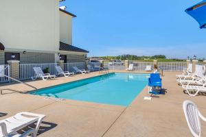 - une piscine avec chaises longues dans l'établissement Comfort Inn & Suites, à Lincoln