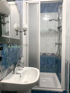 La salle de bains est pourvue d'un lavabo, d'une douche et d'une baignoire. dans l'établissement LENA pokoje gościnne, à Międzyzdroje