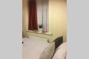 a bedroom with a bed with white sheets and a window at F3 Cosy Single Room (Sandycroft Guest House) in London