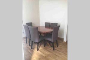 a dining room table with chairs and a wooden floor at F3 Cosy Single Room (Sandycroft Guest House) in London